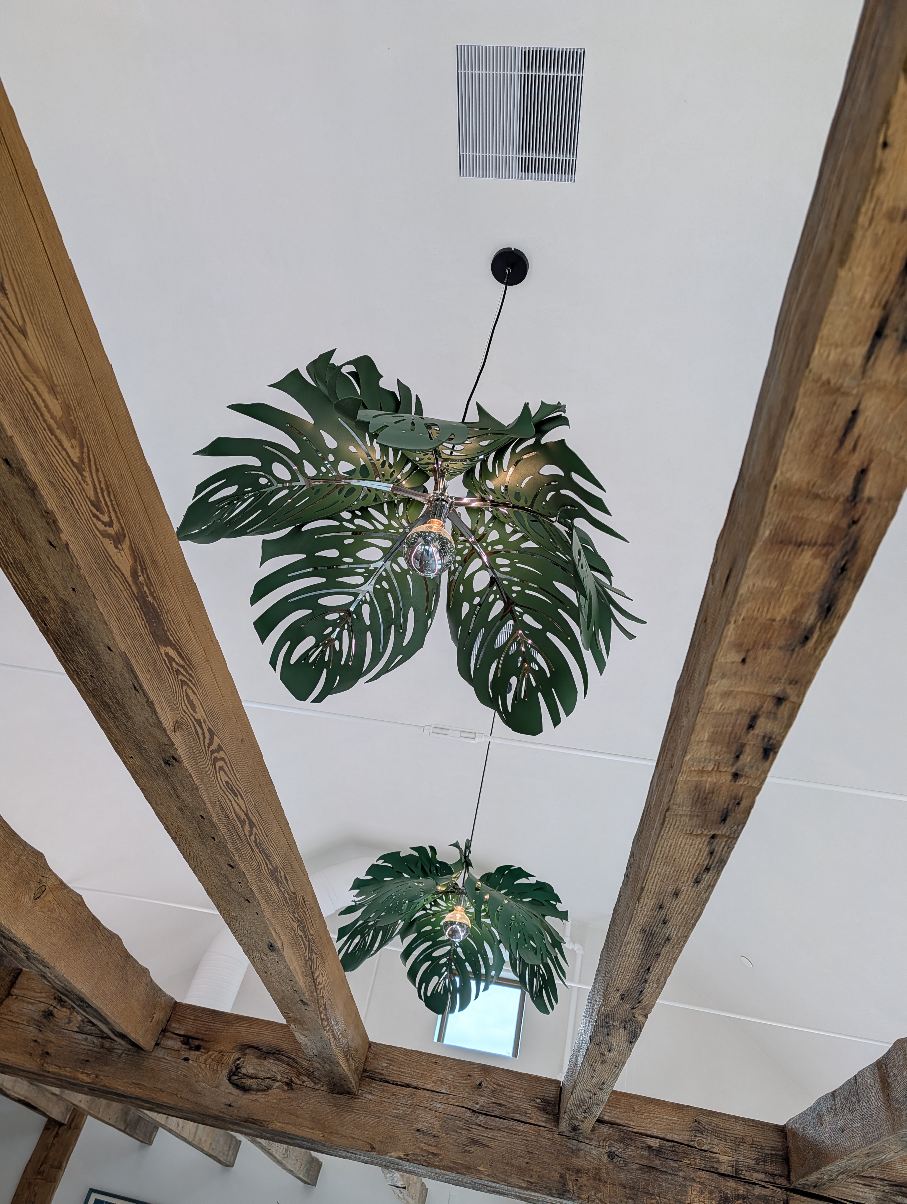 Decorative leaf pendant fixtures installed between exposed beams