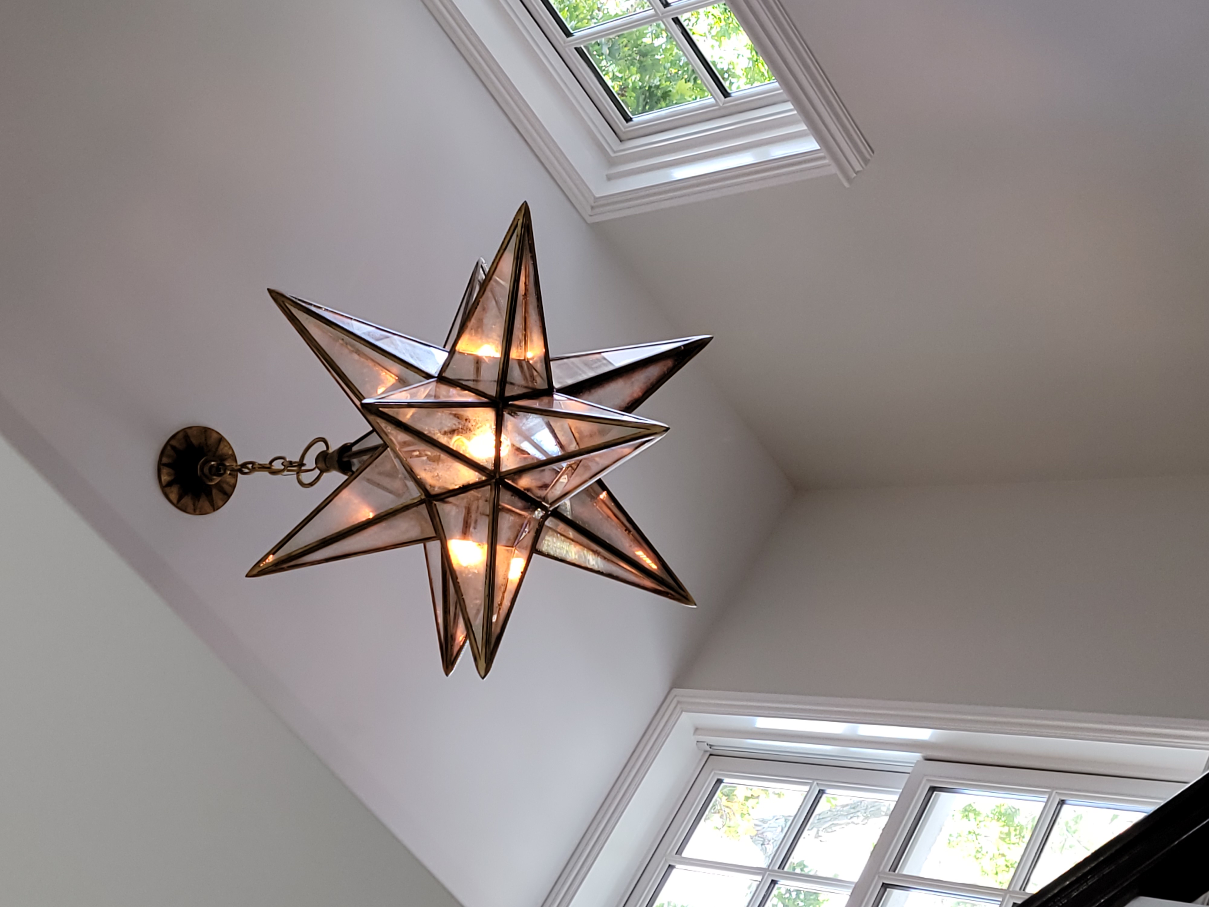 Decorative star pendant fixture installed in a tall stairwell