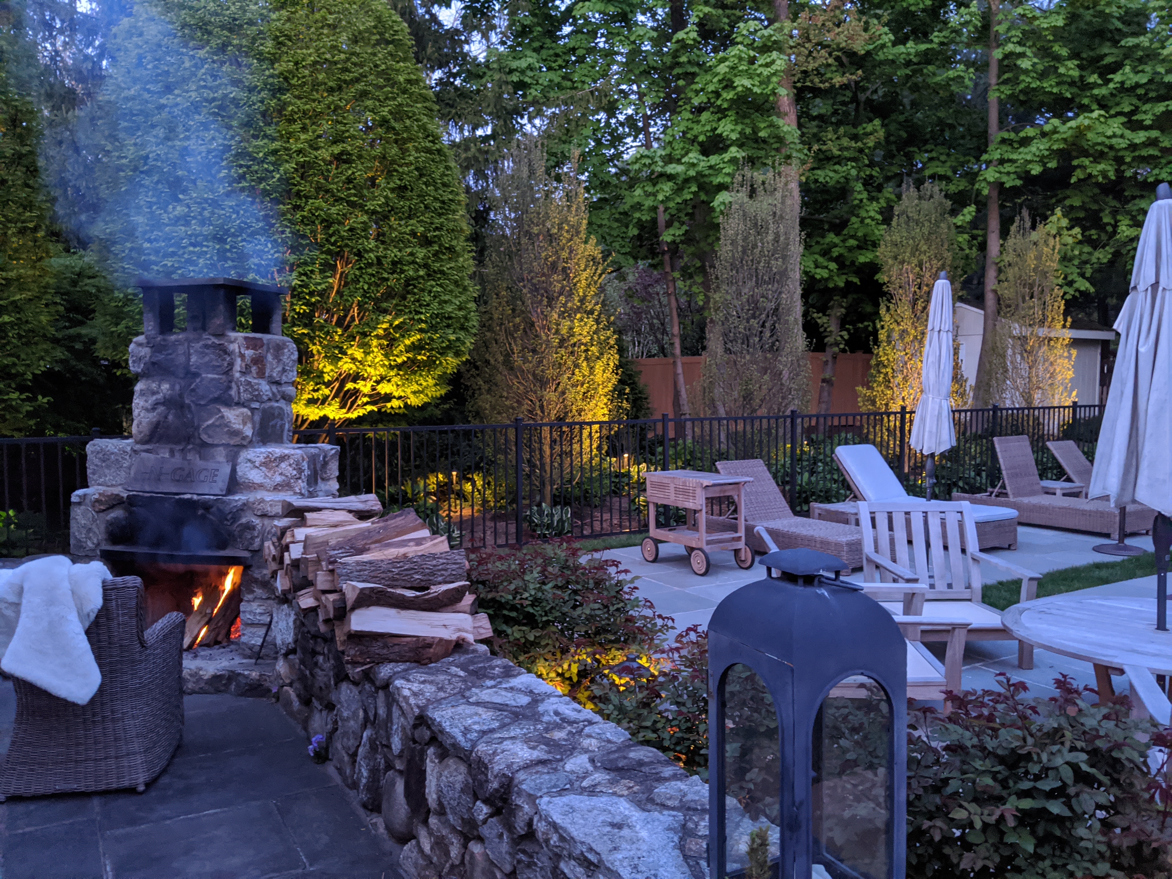Outdoor fireplace and patio with landscape lighting